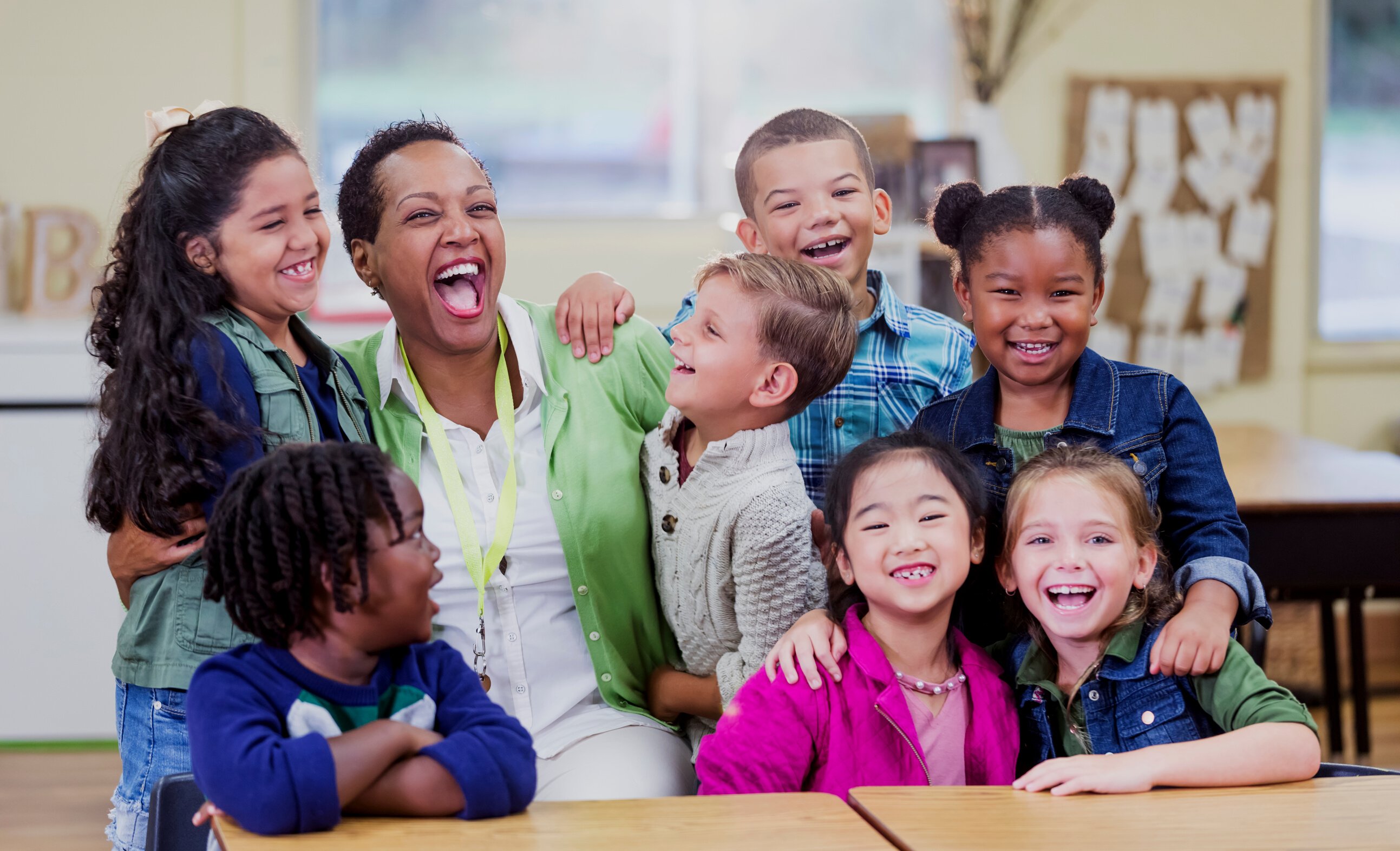 Teacher and elementary school students, fun in classroom